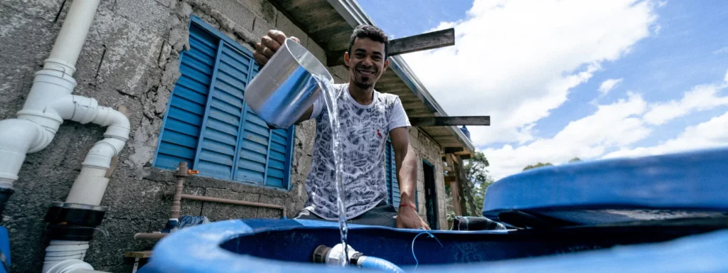 Homem mega feliz ao ser beneficiado com água e saneamento com a aliança da Teto com a Techo