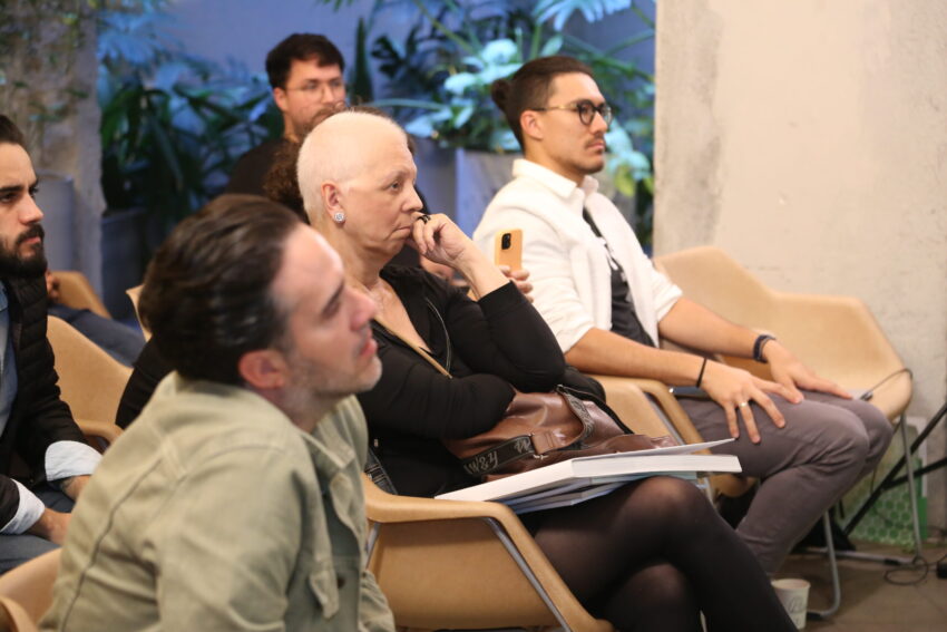 Público assiste a evento sobre moradia e crise climática.