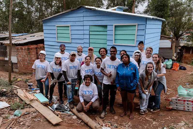 Voluntários em frente a casa construída na comunidade Savoy, em São Paulo