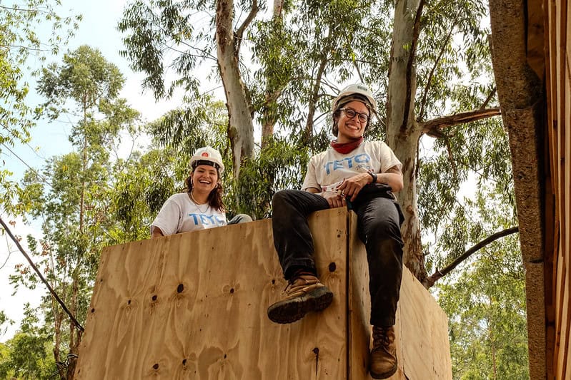 Duas voluntárias sentadas sobre construção
