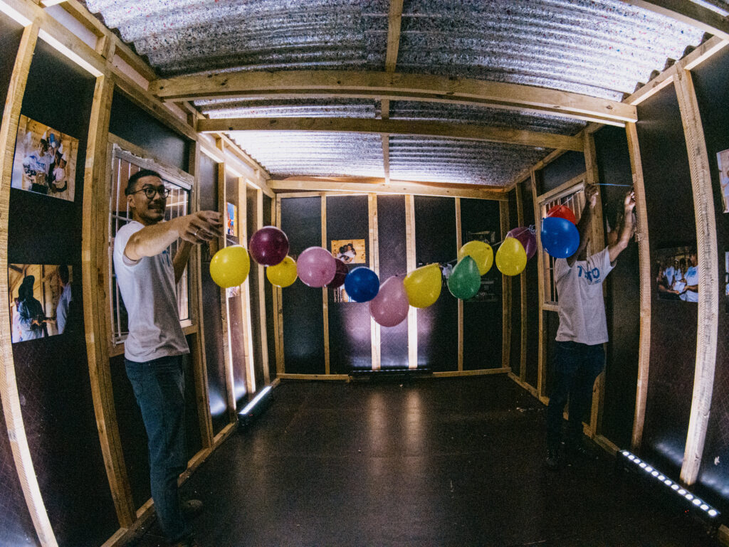 Interior de casa resiliente. Voluntários penduram bexigas para receber convidados.