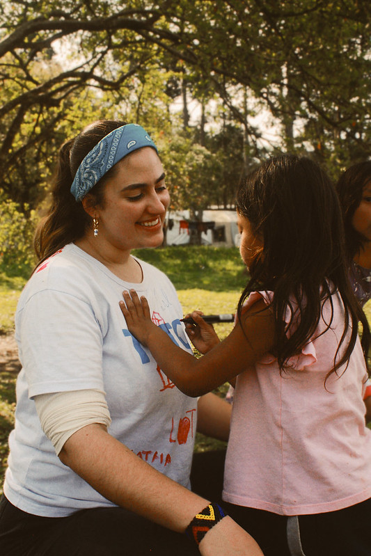 Voluntária da TETO durante interação carinhosa com menina