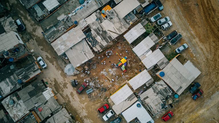 Vista de comunidade com moradias improvisadas e ausência de infraestrutura, destacando a vulnerabilidade territorial.