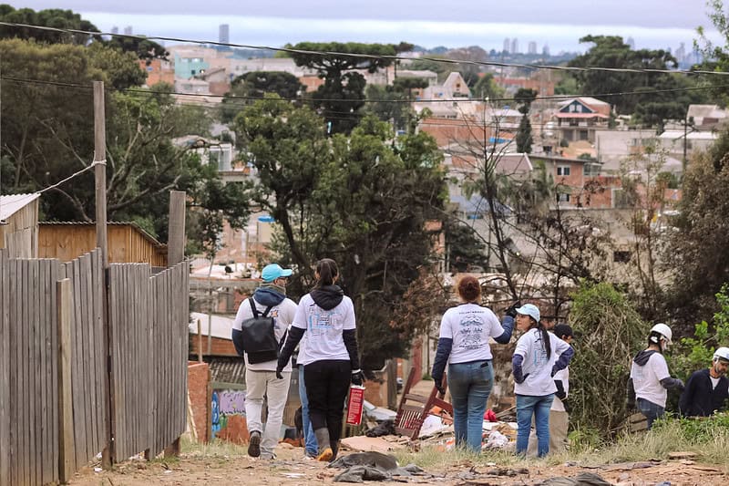 Voluntariado da TETO em comunidade da periferia sem asfalto nas ruas.