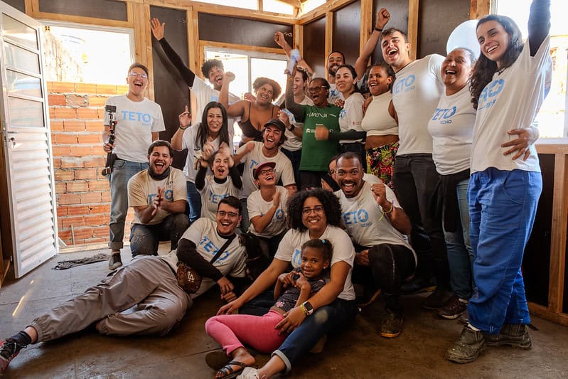 Família e voluntariado da TETO dentro da moradia emergencial construída