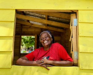 Senhora sorrindo dentro de moradia construída pela TETO Brasil em comunidade