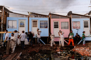 Voluntariado e moradores constroem, lado a lado, moradias em até 48h.