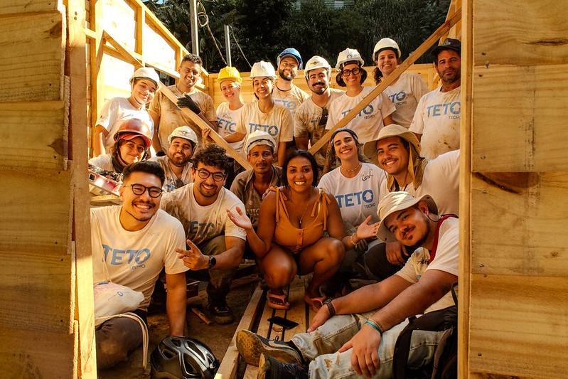 Team of TETO volunteers alongside a resident during the construction of an emergency shelter in the Tribo community, in São Paulo (SP).